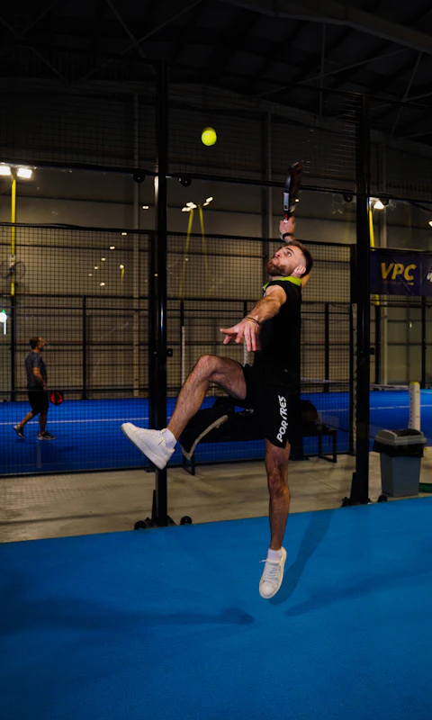 Person spelar padel inomhus