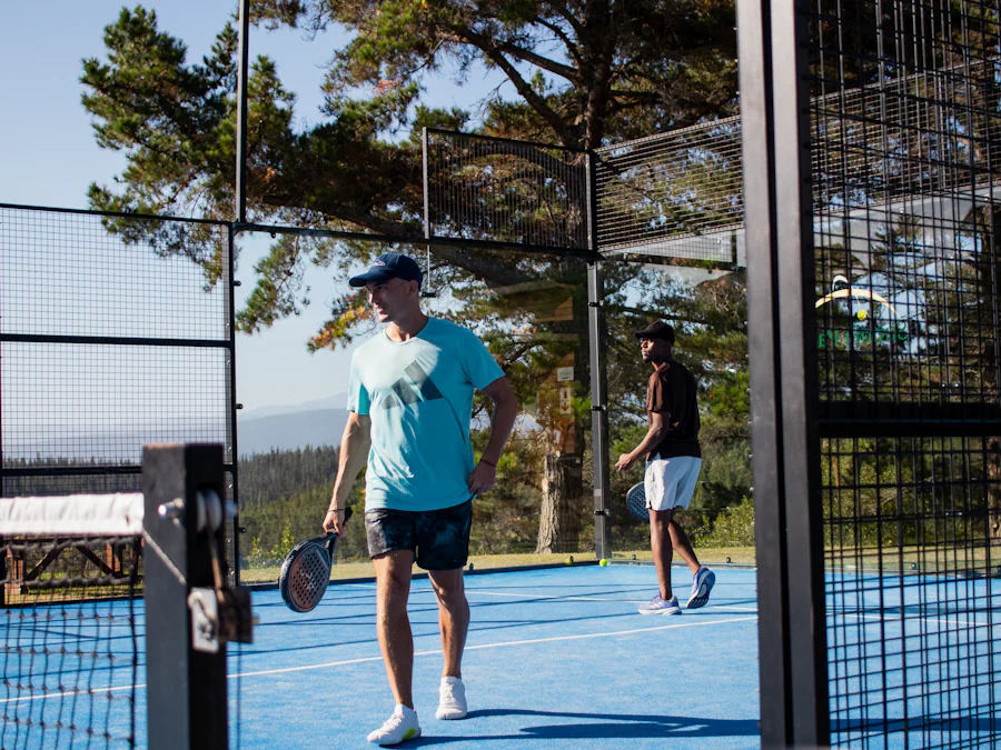 Två personer spelar padel på en blå bana
