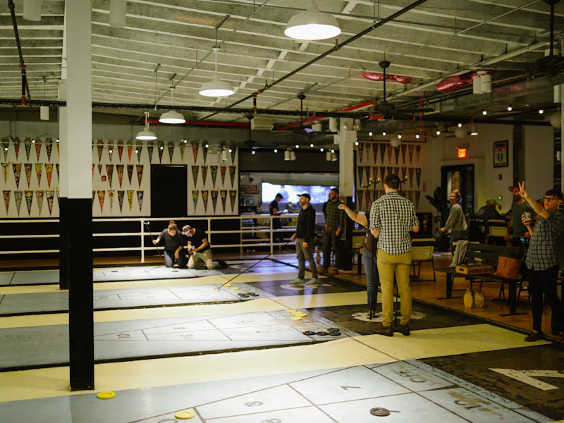 Människor spelar shuffleboard inomhus